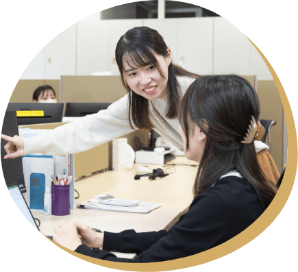 YCSのオフィスで同僚と話す女性社員。海外と関わる仕事に興味を持ち、入社を決めた理由を紹介
