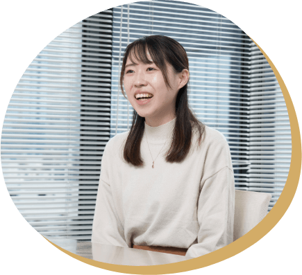 YCSのオフィスで同僚に説明をする女性社員。新しい環境や仕事に挑戦し、変化に対応する力を身につけた成長エピソードを紹介。
