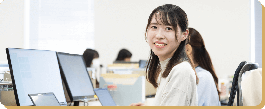 オフィスで働く笑顔の女性社員、ジョブローテーション制度を活用して様々な業務に挑戦し、自己成長を目指している様子